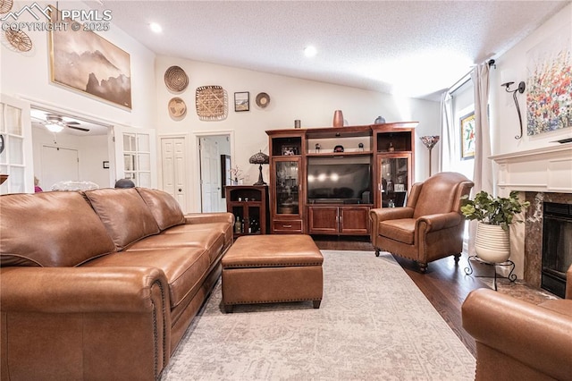 2125 Glenhill Rd, Colorado Springs, CO 80906 - living room with vaulted ceiling, a premium fireplace, wood finished floors, a textured ceiling, and recessed lighting