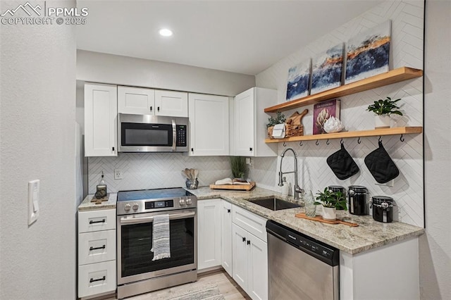 5300 E Cherry Creek Dr Unit 918, Denver, CO 80246 - kitchen with appliances with stainless steel finishes, open shelves, tasteful backsplash, and white cabinets