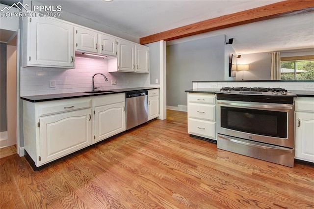 1018 Saturn Dr, Colorado Springs, CO 80905 - kitchen featuring stainless steel appliances, dark countertops, white cabinets, and backsplash
