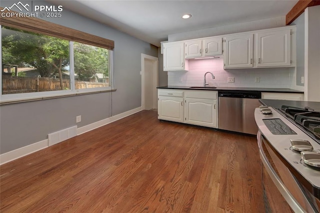 1018 Saturn Dr, Colorado Springs, CO 80905 - kitchen with dishwasher, dark countertops, white cabinets, and recessed lighting
