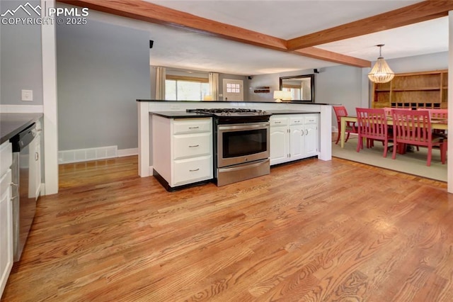 1018 Saturn Dr, Colorado Springs, CO 80905 - kitchen featuring stainless steel appliances, dark countertops, white cabinets, beamed ceiling, and light wood finished floors