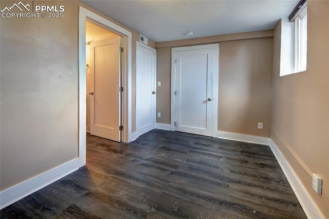 1018 Saturn Dr, Colorado Springs, CO 80905 - unfurnished bedroom with dark wood-style floors and baseboards