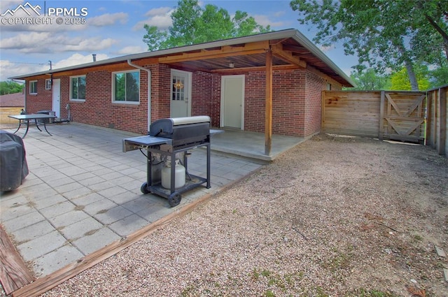 1018 Saturn Dr, Colorado Springs, CO 80905 - back of property with brick siding, a gate, and a patio area