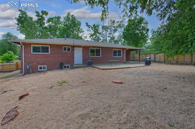 1018 Saturn Dr, Colorado Springs, CO 80905 - back of house with a fenced backyard, brick siding, and a wooden deck