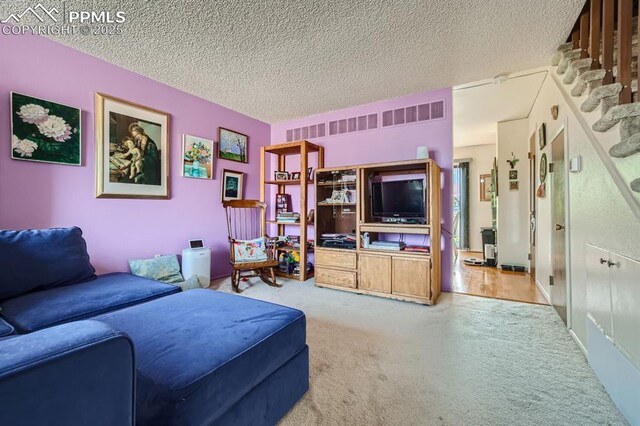 2913 Mesa Rd Unit A, Colorado Springs, CO 80904 - carpeted living area with a textured ceiling and stairway