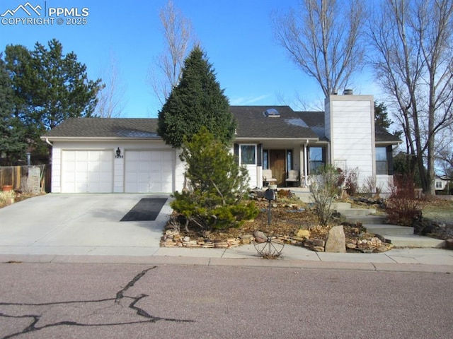5298 Pony Creek Cir, Colorado Springs, CO 80919 - view of front of property with an attached garage, a chimney, driveway, and a shingled roof