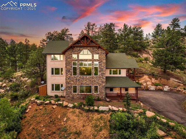 71 Crestone Cir, Florissant, CO 80816 - view of front facade with stone siding, a wooden deck, stucco siding, and driveway