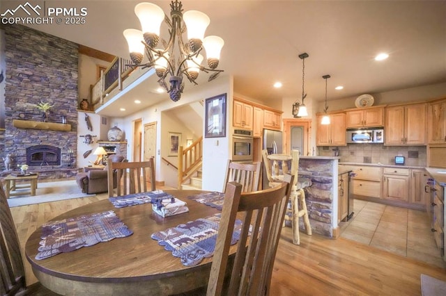 71 Crestone Cir, Florissant, CO 80816 - dining space with a fireplace, stairs, light wood-type flooring, recessed lighting, and a chandelier