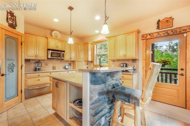 71 Crestone Cir, Florissant, CO 80816 - kitchen with stainless steel microwave, a warming drawer, light brown cabinetry, decorative backsplash, and recessed lighting