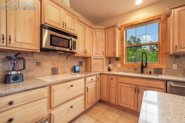 71 Crestone Cir, Florissant, CO 80816 - kitchen with appliances with stainless steel finishes, light brown cabinets, light stone counters, tasteful backsplash, and light tile patterned flooring