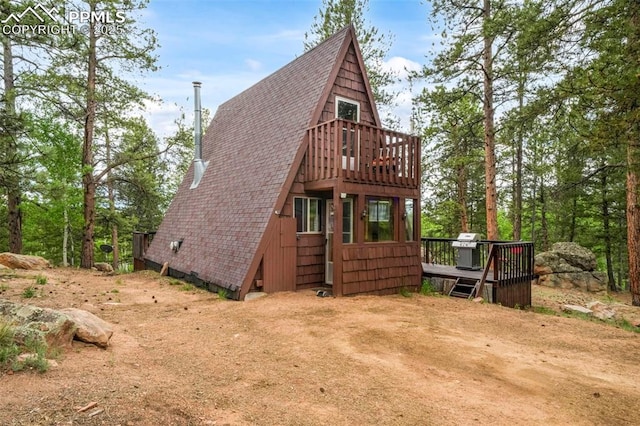 71 Crestone Cir, Florissant, CO 80816 - rear view of property featuring a shingled roof, a wooden deck, and a balcony