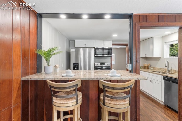 121 Via, San Miguel, Manitou Springs, CO 80829 - kitchen featuring stainless steel appliances, light stone counters, dark wood-style floors, and white cabinets
