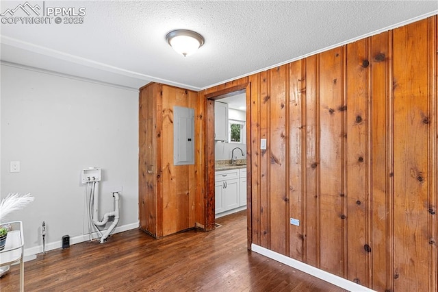 121 Via, San Miguel, Manitou Springs, CO 80829 - empty room with electric panel, dark wood-type flooring, a textured ceiling, and wood walls