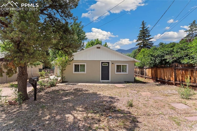 121 Via, San Miguel, Manitou Springs, CO 80829 - back of house with a fenced backyard, a mountain view, and stucco siding