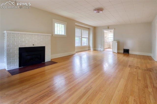 620 E Fontanero St, Colorado Springs, CO 80907 - unfurnished living room featuring light wood finished floors and a brick fireplace
