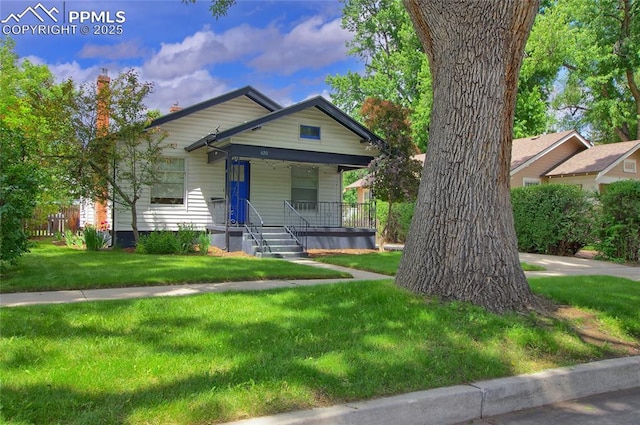 620 E Fontanero St, Colorado Springs, CO 80907 - view of front of house with covered porch, a front yard, and a chimney