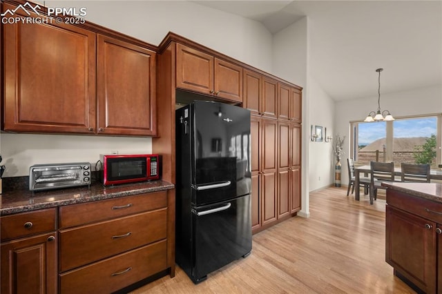 106 Red Tail Blvd, Buena Vista, CO 81211 - kitchen with freestanding refrigerator, lofted ceiling, a chandelier, light wood-style floors, and decorative light fixtures