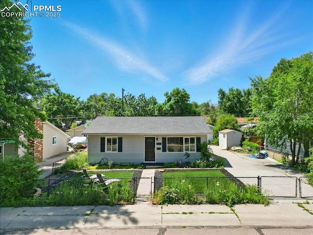 1137 Pando Ave, Colorado Springs, CO 80905 - view of front facade with a gate, a shed, and a fenced front yard