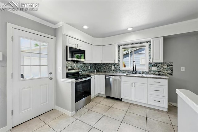 1137 Pando Ave, Colorado Springs, CO 80905 - kitchen featuring appliances with stainless steel finishes, backsplash, white cabinets, light tile patterned floors, and recessed lighting