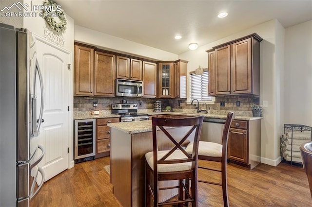10280 Abrams Dr, Colorado Springs, CO 80925 - kitchen featuring stainless steel appliances, beverage cooler, dark wood finished floors, backsplash, and recessed lighting