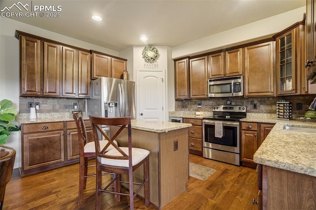 10280 Abrams Dr, Colorado Springs, CO 80925 - kitchen featuring stainless steel appliances, a center island, dark wood-type flooring, decorative backsplash, and recessed lighting