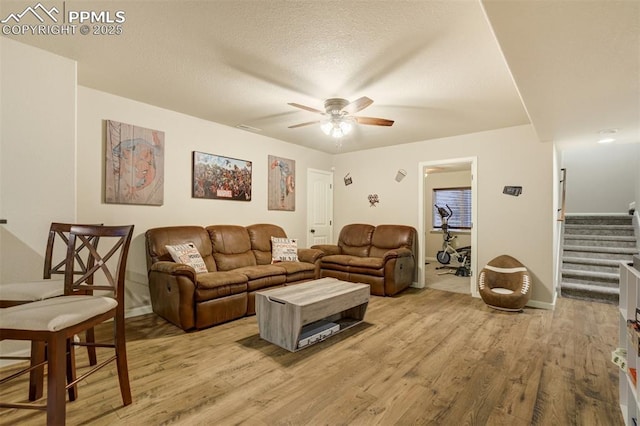 10280 Abrams Dr, Colorado Springs, CO 80925 - living area featuring a ceiling fan, light wood-style floors, stairway, and a textured ceiling