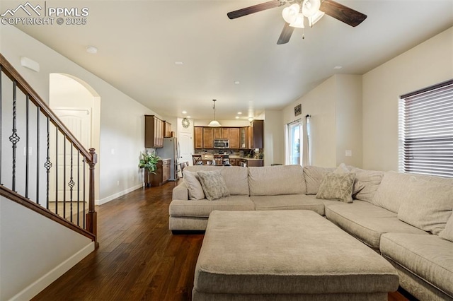 10280 Abrams Dr, Colorado Springs, CO 80925 - living room with dark wood-style flooring, ceiling fan, arched walkways, and stairs