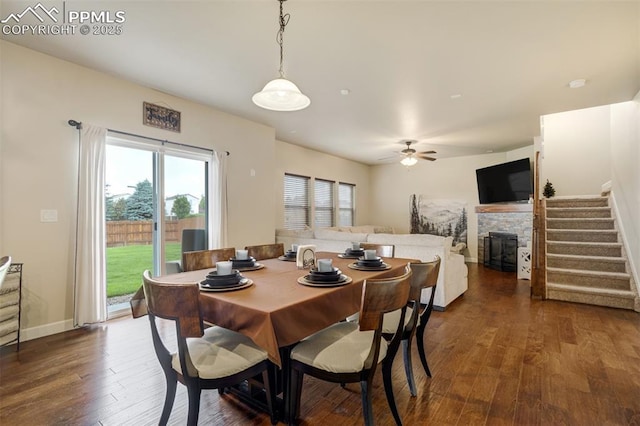 10280 Abrams Dr, Colorado Springs, CO 80925 - dining area with dark wood-style flooring, a stone fireplace, stairway, and ceiling fan