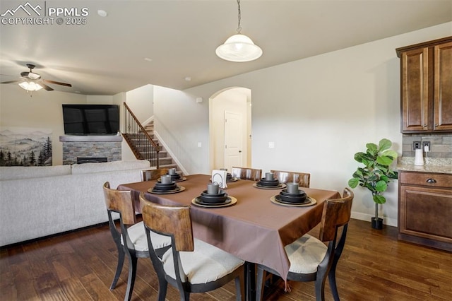 10280 Abrams Dr, Colorado Springs, CO 80925 - dining space featuring arched walkways, ceiling fan, dark wood-style floors, and stairway