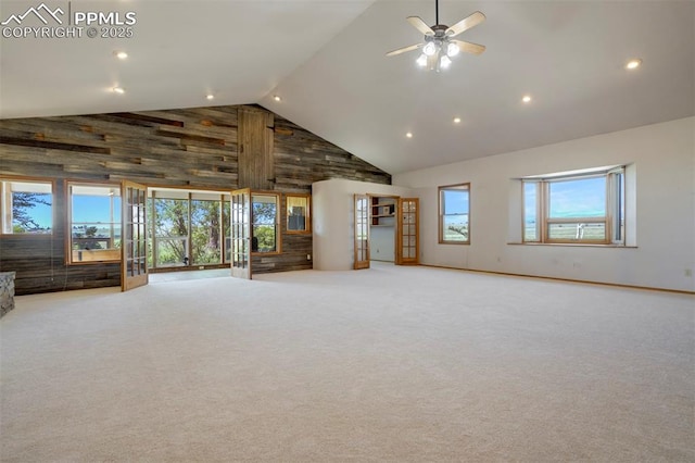 2550 Slocum Rd, Peyton, CO 80831 - unfurnished living room featuring high vaulted ceiling, carpet flooring, ceiling fan, recessed lighting, and wood walls