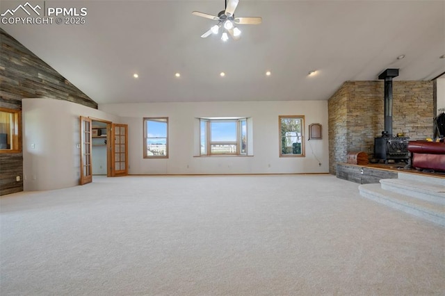 2550 Slocum Rd, Peyton, CO 80831 - unfurnished living room featuring a wood stove, carpet, a ceiling fan, high vaulted ceiling, and recessed lighting