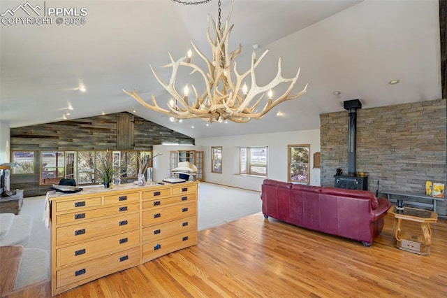2550 Slocum Rd, Peyton, CO 80831 - living area with a wood stove, lofted ceiling, wood finished floors, and a chandelier