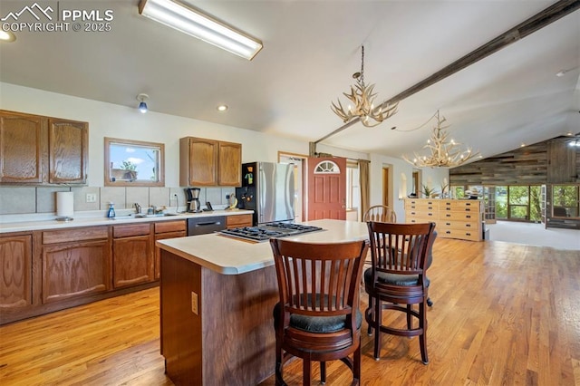 2550 Slocum Rd, Peyton, CO 80831 - kitchen featuring appliances with stainless steel finishes, a chandelier, light countertops, lofted ceiling, and light wood finished floors