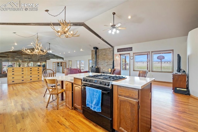 2550 Slocum Rd, Peyton, CO 80831 - kitchen featuring gas range, ceiling fan, open floor plan, a chandelier, and high vaulted ceiling