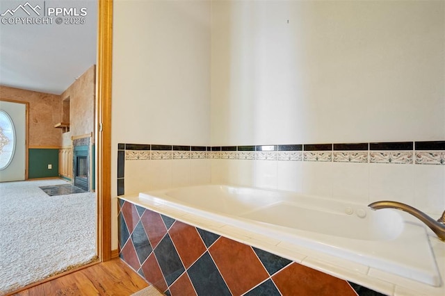 2550 Slocum Rd, Peyton, CO 80831 - full bath with a garden tub, a fireplace with flush hearth, and wood finished floors