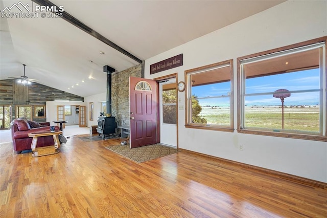 2550 Slocum Rd, Peyton, CO 80831 - foyer with a wood stove, wood finished floors, ceiling fan, beamed ceiling, and high vaulted ceiling