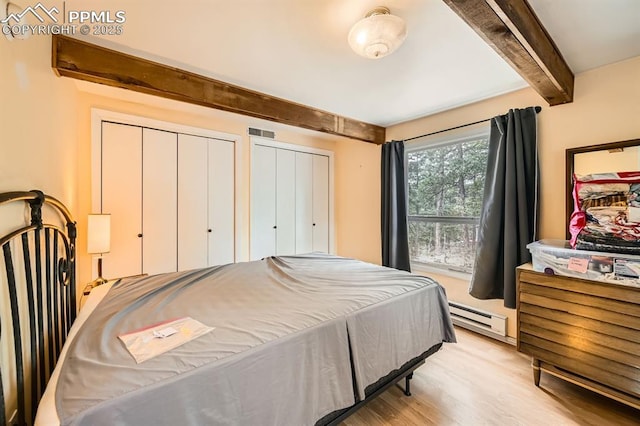 376 Gardenia Rd, Woodland Park, CO 80863 - bedroom with a baseboard radiator, beam ceiling, light wood-type flooring, and multiple closets