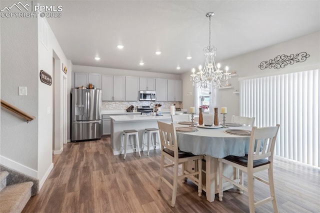 8101 Goldenray Pl, Colorado Springs, CO 80908 - dining space featuring wood finished floors, recessed lighting, a chandelier, and stairs