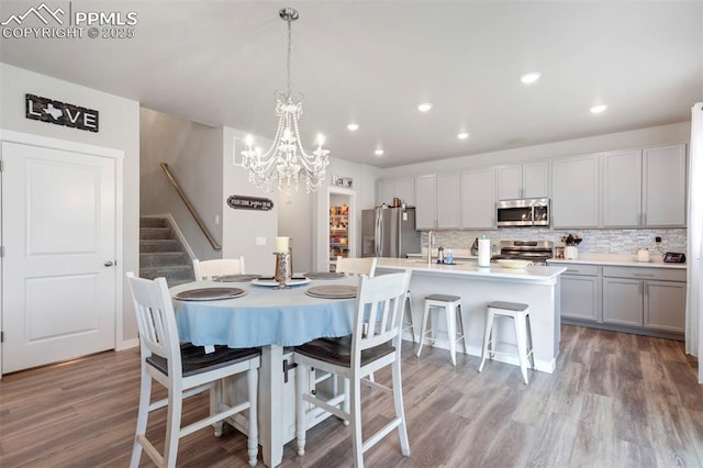 8101 Goldenray Pl, Colorado Springs, CO 80908 - dining area with stairs, light wood-style flooring, a chandelier, and recessed lighting