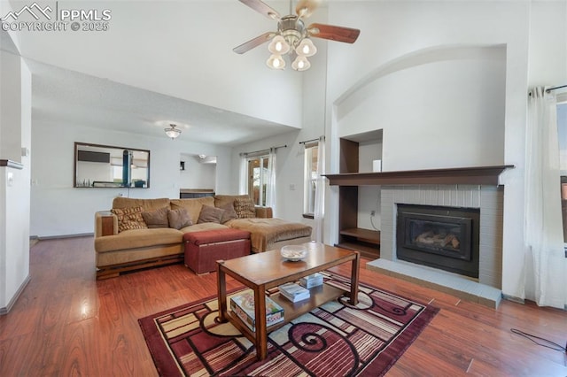 9503 Brisk Breeze Ct, Colorado Springs, CO 80925 - living area with a fireplace, wood finished floors, a ceiling fan, and a high ceiling