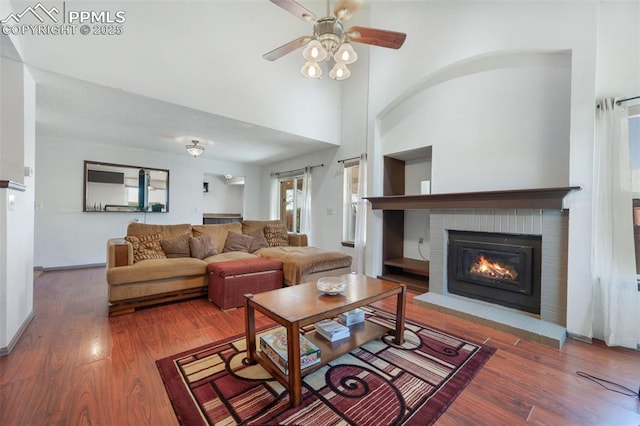 9503 Brisk Breeze Ct, Colorado Springs, CO 80925 - living area featuring a fireplace, wood finished floors, a ceiling fan, and a towering ceiling