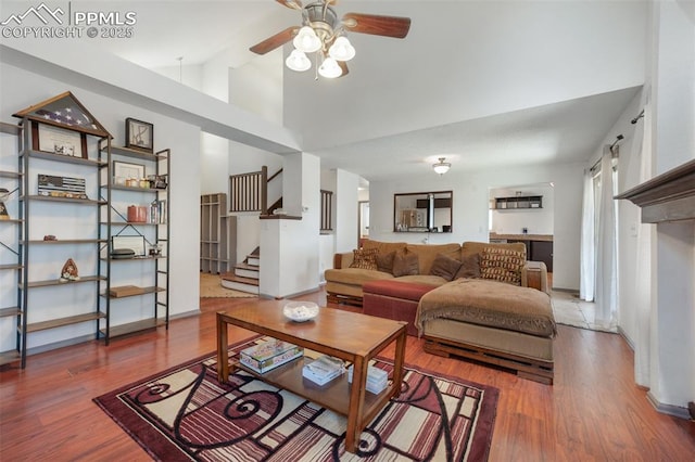 9503 Brisk Breeze Ct, Colorado Springs, CO 80925 - living room featuring ceiling fan, stairway, wood finished floors, and high vaulted ceiling