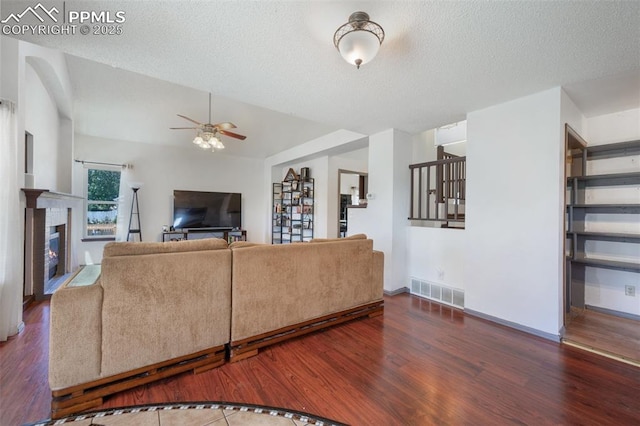 9503 Brisk Breeze Ct, Colorado Springs, CO 80925 - living room with ceiling fan, wood finished floors, a textured ceiling, a glass covered fireplace, and stairway