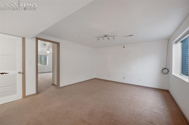 9503 Brisk Breeze Ct, Colorado Springs, CO 80925 - unfurnished room featuring light carpet and rail lighting