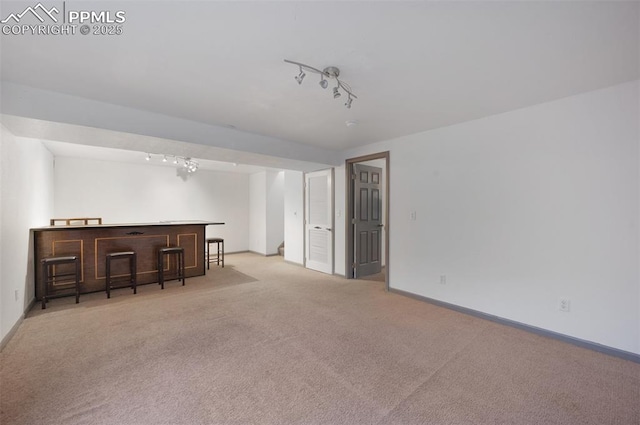 9503 Brisk Breeze Ct, Colorado Springs, CO 80925 - unfurnished living room with a bar, rail lighting, and carpet