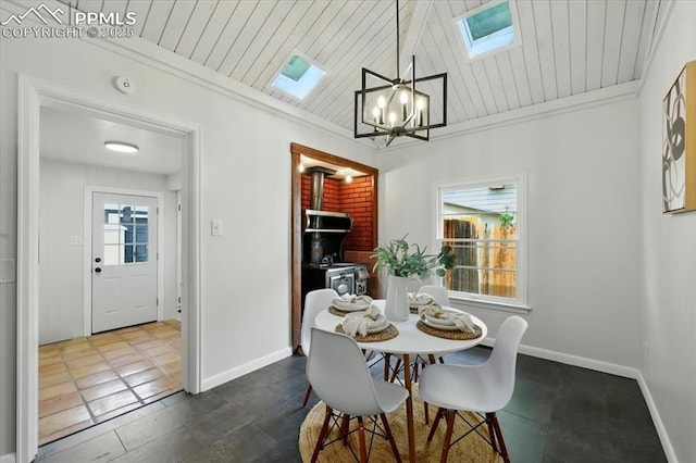 1314 Pioneer Rd, Colorado Springs, CO 80907 - dining space with a skylight, a wood stove, a chandelier, wooden ceiling, and ornamental molding