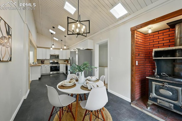 1314 Pioneer Rd, Colorado Springs, CO 80907 - dining area featuring a wood stove, a chandelier, crown molding, a skylight, and high vaulted ceiling