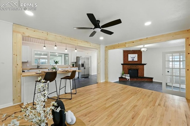 1314 Pioneer Rd, Colorado Springs, CO 80907 - living area with dark wood-style floors, ceiling fan, recessed lighting, a brick fireplace, and baseboard heating