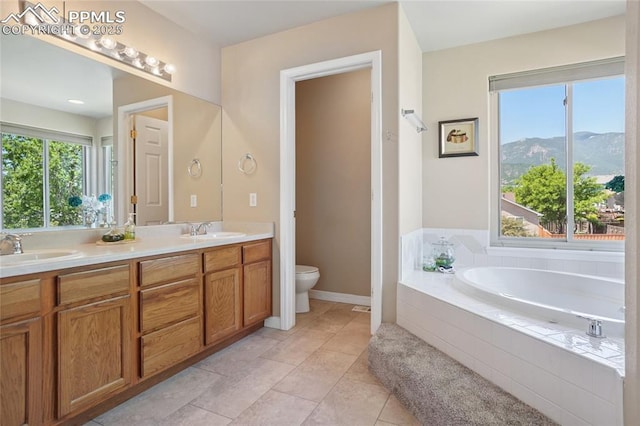 392 Pyrite Ter, Colorado Springs, CO 80905 - full bath featuring double vanity, a garden tub, a mountain view, and tile patterned floors