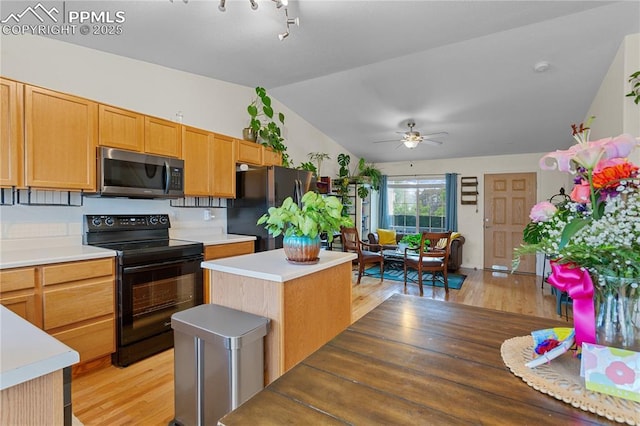 6355 Casual Dr, Colorado Springs, CO 80923 - kitchen featuring stainless steel microwave, electric range, freestanding refrigerator, lofted ceiling, and light wood-style floors
